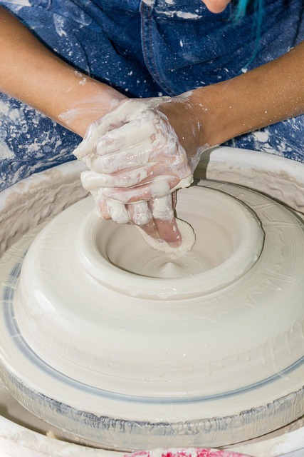 Artisan hands working with pottery clay in a workshop